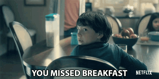 a young boy sits at a table with the words " you missed breakfast " written below him