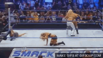 two women are wrestling in a wrestling ring with a sign that says smack on it