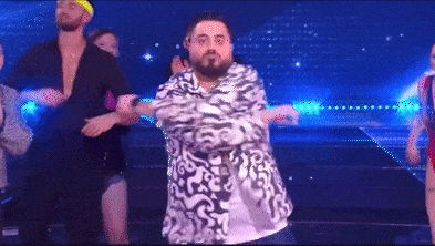 a man with a beard is dancing on a stage in front of a group of dancers .