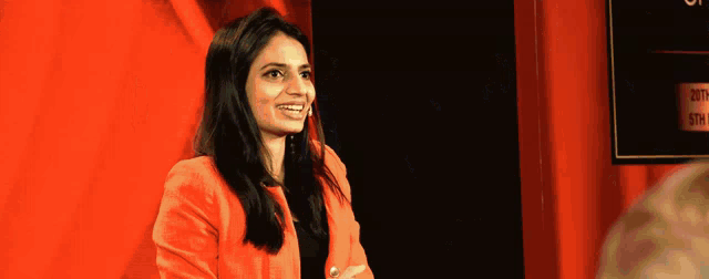 a woman in a red jacket is smiling in front of a sign that says ' both ' on it