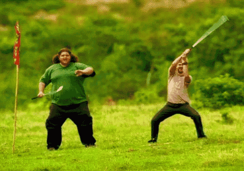 a man in a green shirt is swinging a bat at another man
