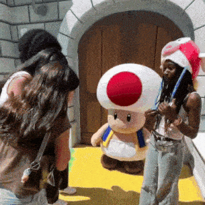 a group of people standing around a stuffed toad