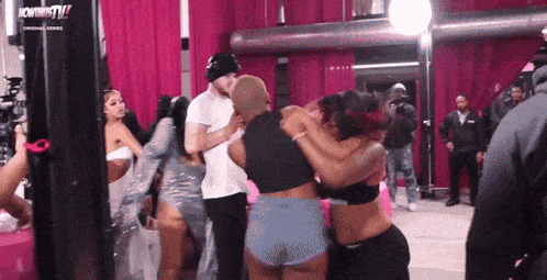 a group of people are hugging each other in front of a sign that says now thats tv