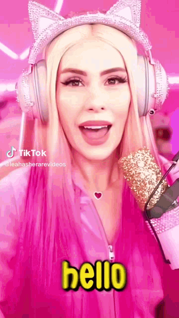 a woman wearing headphones and a cat ear headband says hello .