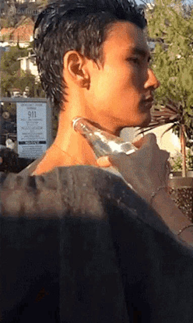 a man 's neck is being massaged in front of a sign that says 911 on it