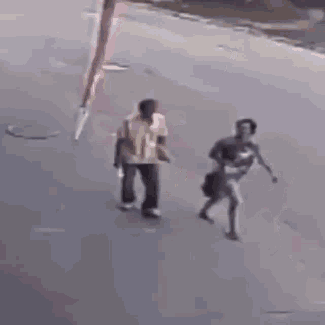 a person is laying on the ground next to a tire that is hanging from a pole .