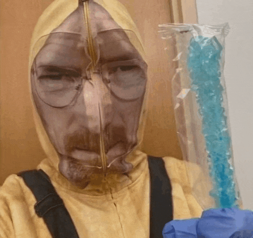 a man in a breaking bad costume is holding a bag of blue crystals
