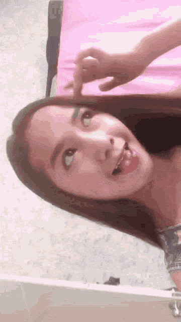 a girl is sticking her tongue out and looking up