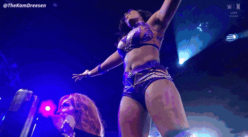 a woman in a purple and gold outfit is dancing on a stage with the hashtag #thekamdreesen