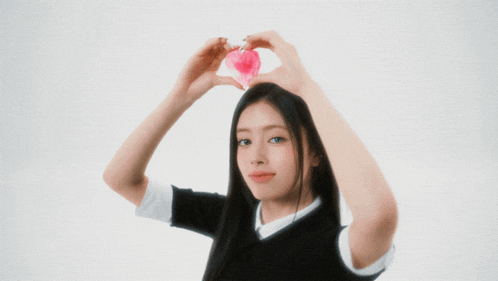 a girl holds a pink heart in her hands