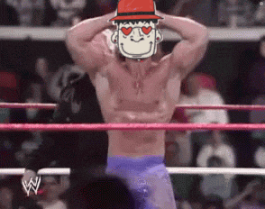 a man in a wrestling ring wearing a hat with a cartoon face on it