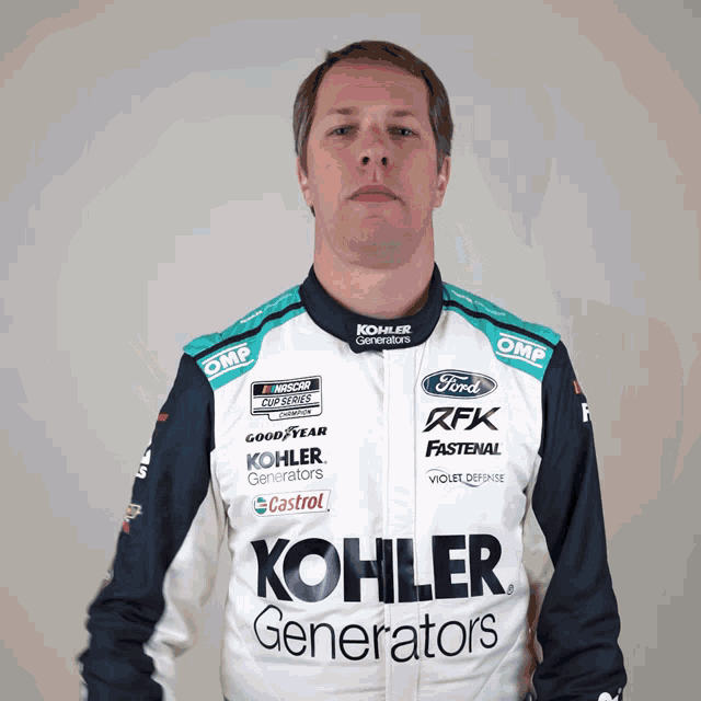 a man wearing a kohler generators jacket poses for a picture