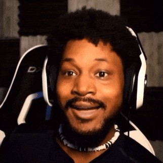 a man with a beard is wearing headphones and a necklace and smiling .