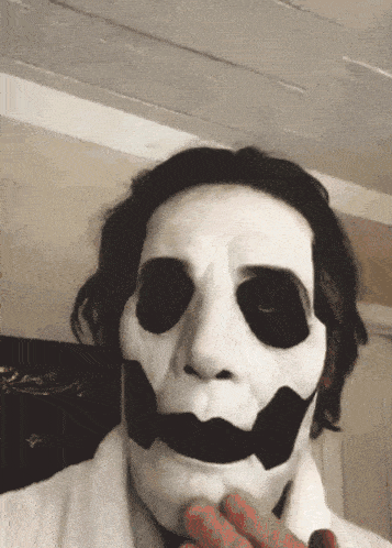 a man wearing a white skeleton mask with black spots on his face