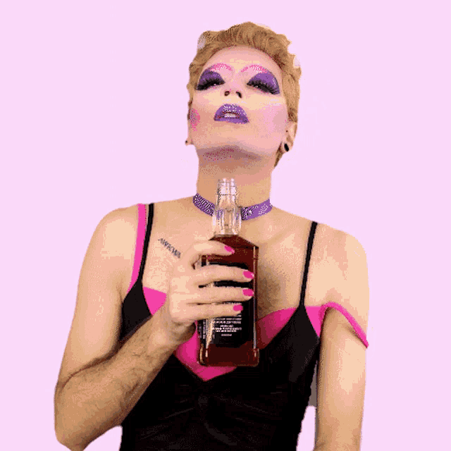 a drag queen holds a bottle of jack daniels