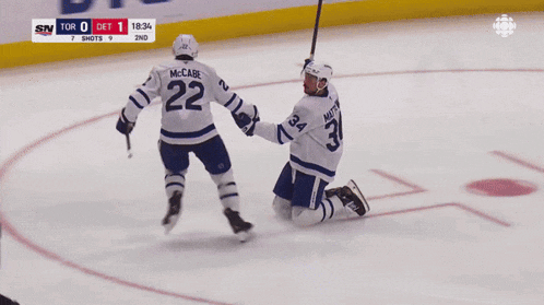 a hockey player with the number 22 on his jersey holds hands with another player