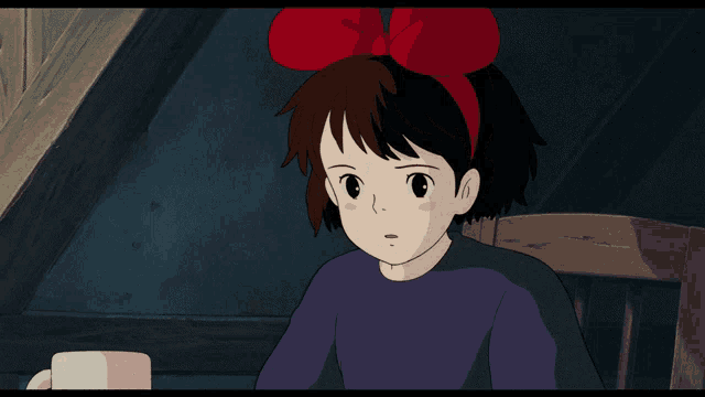 a girl with a red bow on her head looks at something