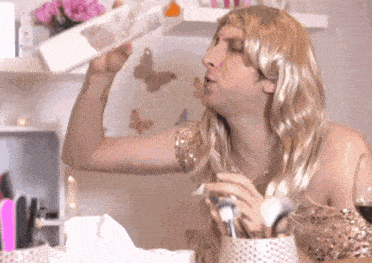 a woman in a wig is drinking from a bottle of water
