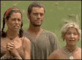 a man and two women are standing next to each other on a green field .