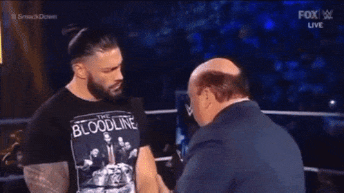a bald man in a suit is being punched in the face .