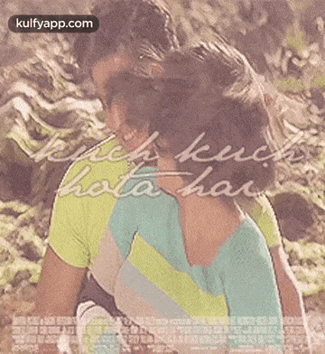 a man and a woman are hugging each other in front of a movie poster for a movie .