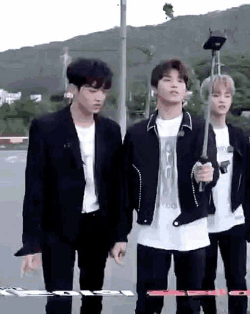 a group of young men are standing next to each other and one of them is holding a knife .