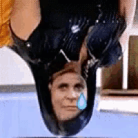 a man with a snail on his head is hanging upside down in a pool .