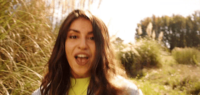 a woman with her tongue hanging out is standing in a field