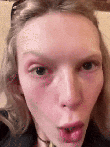a close up of a woman 's face making a funny face