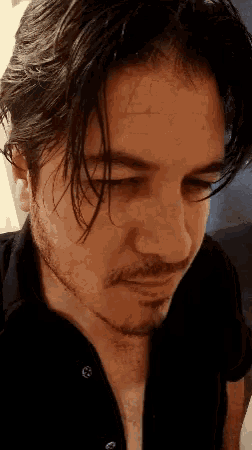 a close up of a man 's face with a black shirt on