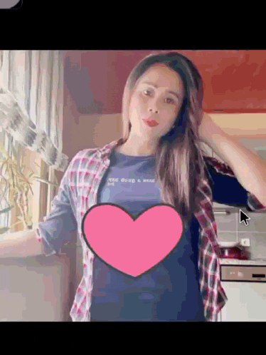 a woman in a plaid shirt is standing in front of a heart