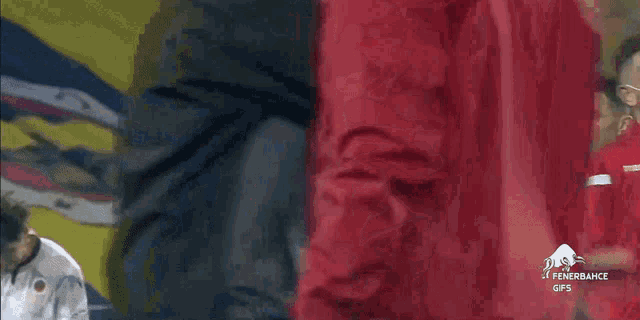a man without a shirt is standing next to another man in a red shirt .