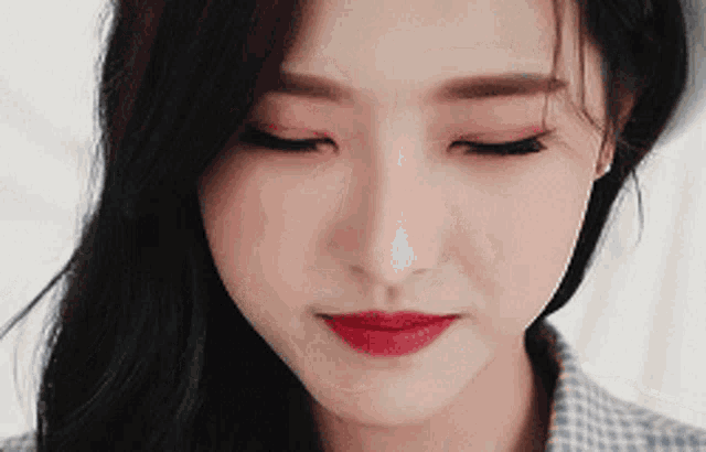 a close up of a woman 's face with her eyes closed and red lipstick on her lips
