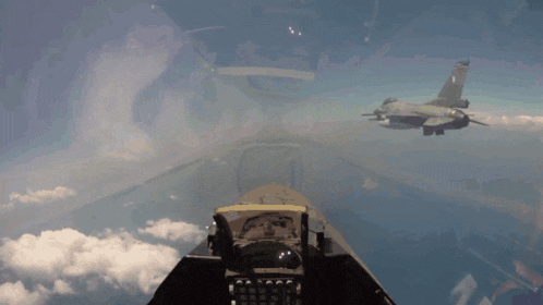 two fighter jets are flying in the sky and one has a greek flag on the tail