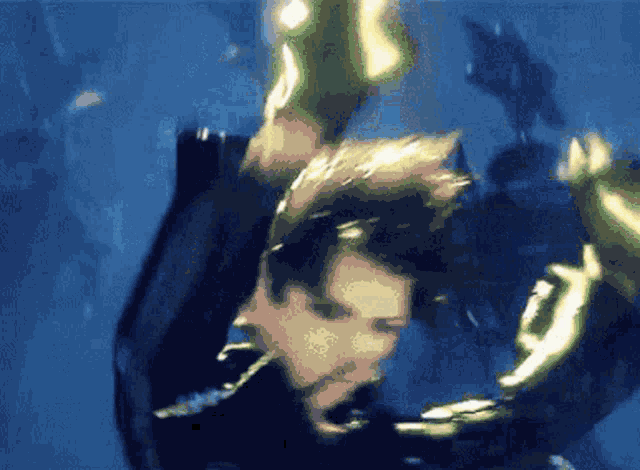 a man in a black suit is swimming in the ocean .