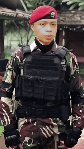 a soldier wearing a red beret has the letter d on his chest