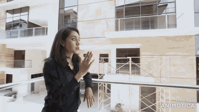 a woman standing in front of a building with the words made in animatica on the bottom