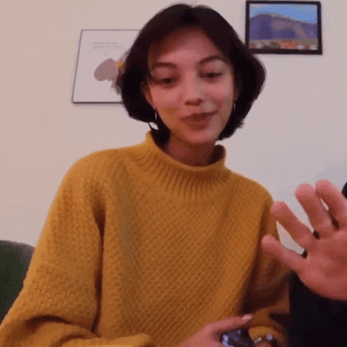 a woman wearing a yellow sweater is smiling