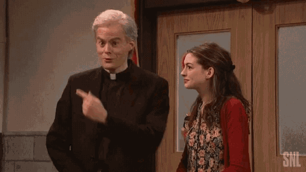 a man in a priest 's robe is standing next to two women .