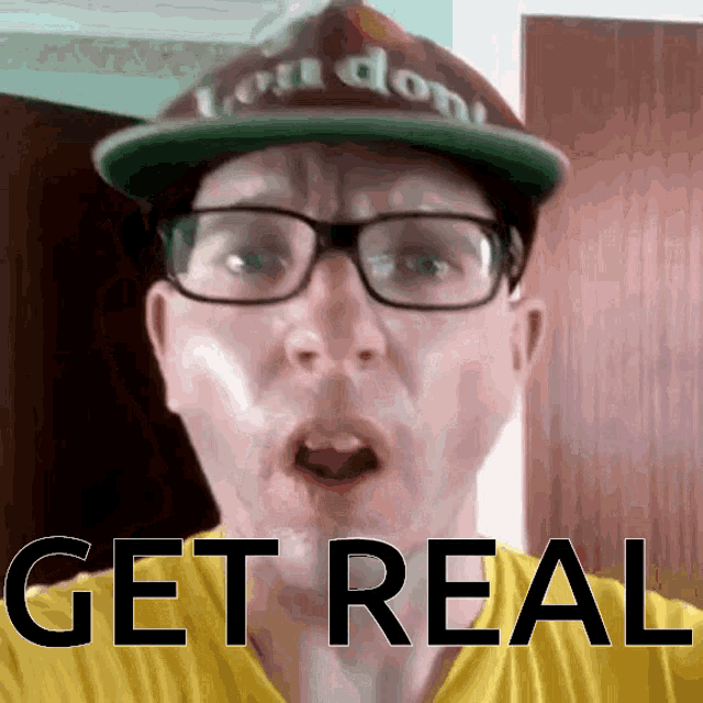a man wearing glasses and a hat with the word get real on his shirt
