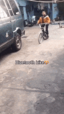 a young boy is riding a bluetooth bike in a parking lot .