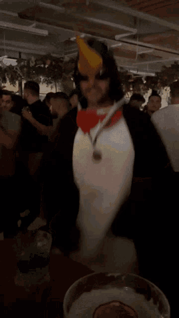 a man in a cat in the hat costume is dancing in a crowded room