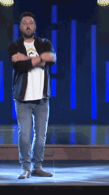 a man with a beard is dancing on stage