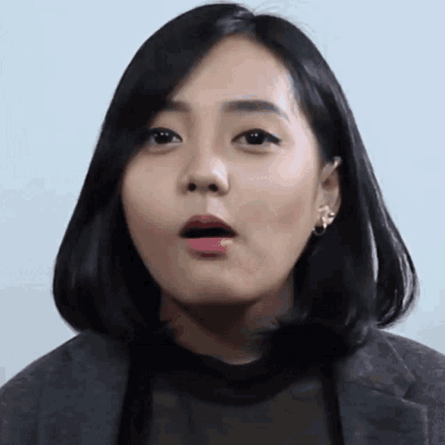 a close up of a woman making a surprised face