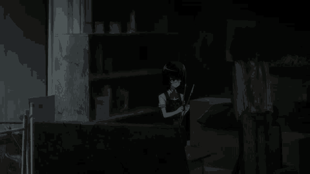 a dark room with a girl holding a stick