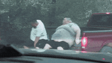 two men are standing in the back of a truck