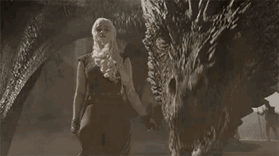 a woman is standing next to a large dragon with a sword in her hand .