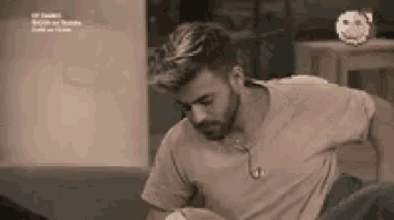 a man with a beard is sitting on a couch in a room .