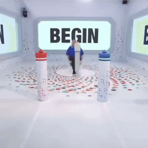 a white room with a blue screen and a few white cylinders on the floor