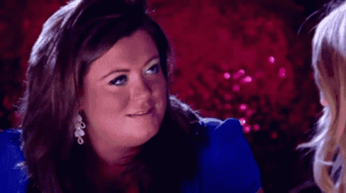 a woman in a blue shirt is talking to another woman .